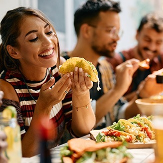 Woman smiling while eating lunch with friends at restaurant