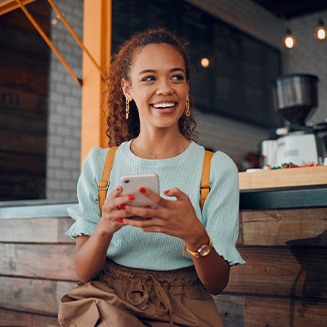 Smiling woman sitting on barstool at restaurant