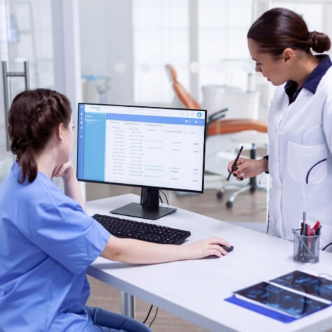 Dentist and team member looking at computer