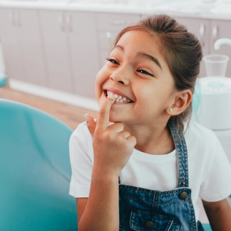 Little girl pointing to her smile