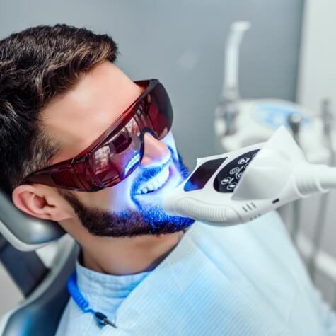 Man having teeth whitened at dentist's office