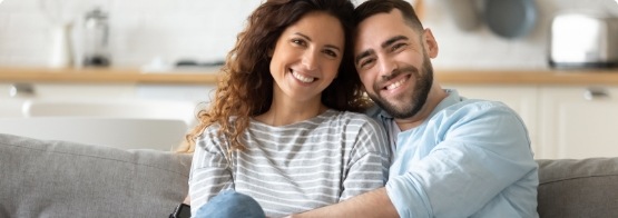 Man and woman sitting on a couch after receiving dental services in Fulshear