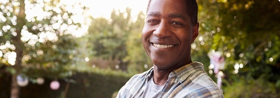 Man in patterned shirt standing outside and smiling