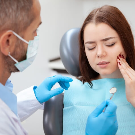 Woman with tooth pain visiting emergency dentist in Fulshear