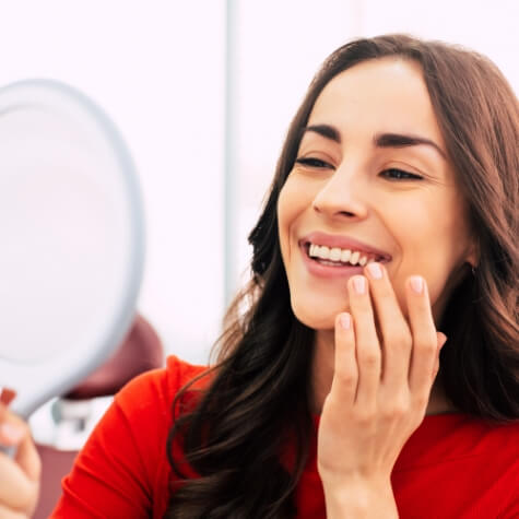 Woman admiring smile after receiving dental implants in Fulshear