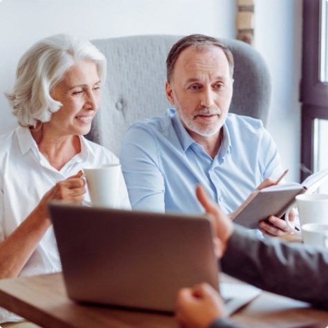 Showing two people information about dental insurance in Fulshear on laptop