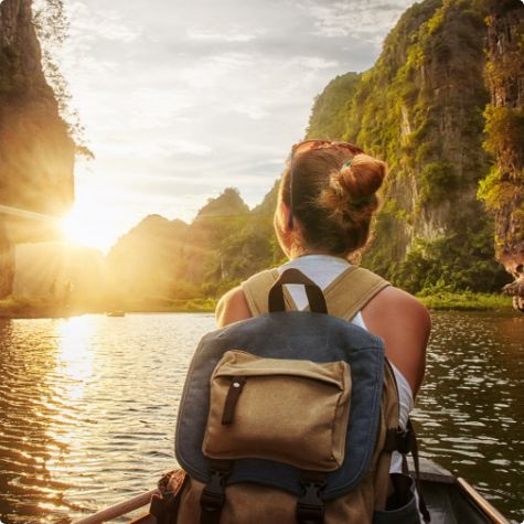 Woman sitting in boat watching sunrise