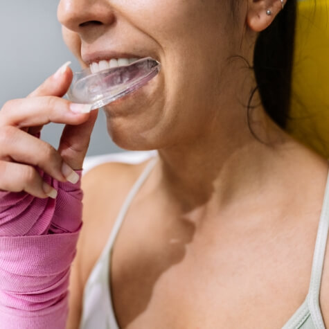 Woman putting in a nightguard for bruxism