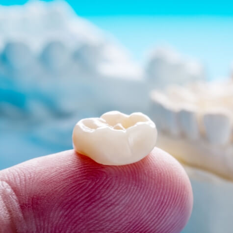 Close-up of dental crown on finger