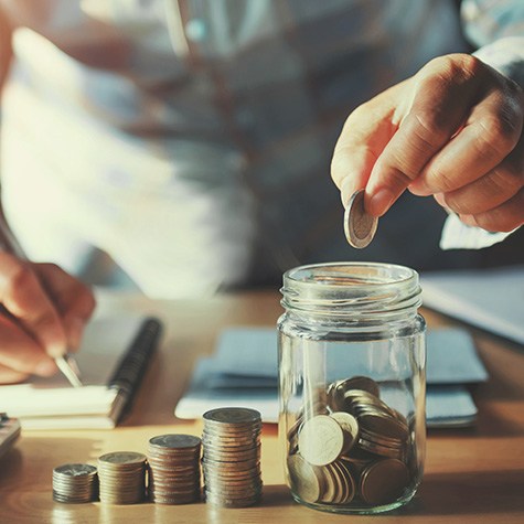 Someone putting coins in a jar