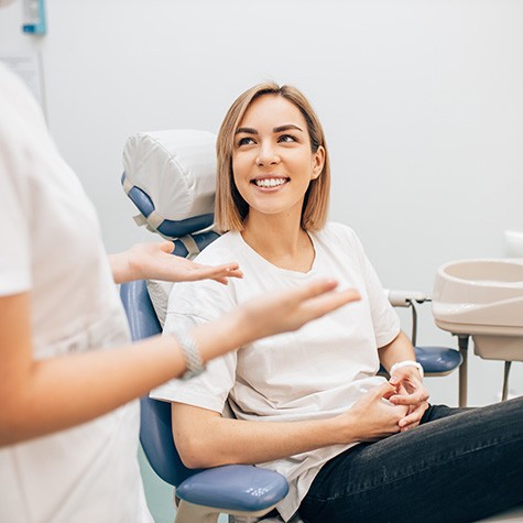 a smiling patient with a shade chart in front of them